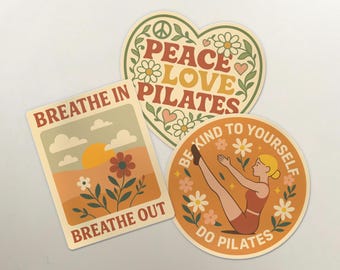 May include: Three retro-style stickers with motivational phrases. One is heart-shaped with "Peace Love Pilates", another rectangular with "Breathe In Breathe Out", and the last is round with "Be Kind To Yourself Do Pilates". The stickers have a neutral color palette.