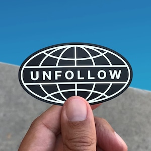 May include: A black and white sticker with a globe design and the word "UNFOLLOW" printed in white.
