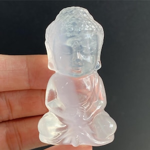 May include: A small, white, translucent, carved figurine of a meditating Buddha.