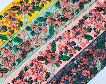 May include: Four embroidered trim ribbons in yellow, green, pink, and gray with floral designs in shades of pink, green, brown, and blue.