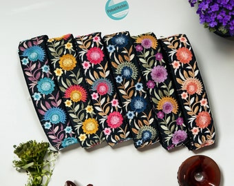 May include: Six black fabric trims with colorful floral embroidery. The trims feature different floral patterns with varying colors, including pink, blue, yellow, and orange.