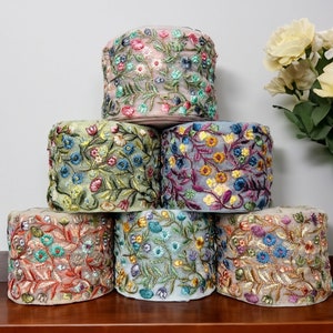 以下が含まれることがあります： ピンク、グリーン、ブルー、ゴールドなど、さまざまな色の花柄刺繍トリムが6個巻かれたスプールです。トリムは、繊細な花柄のデザインが施された透き通った生地で作られています。