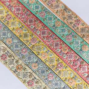 Puede incluir: Cinco galones de diferentes colores con un patrón floral. Los galones son en tonos de amarillo, azul, verde, rosa y beige.