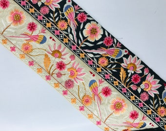 Peut inclure: Deux rubans de garniture brodés avec des motifs floraux et d'oiseaux. Le ruban du haut est noir avec des broderies dorées, roses et blanches. Le ruban du bas est crème avec des broderies dorées, roses et blanches.