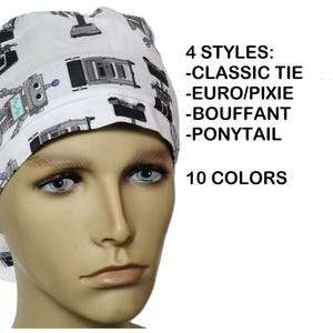 May include: White surgical scrub cap with a repeating pattern of gray and black robots. The cap is shown on a mannequin. Text on the image reads "4 Styles: Classic Tie, Euro/Pixie, Bouffant, Ponytail" and "10 Colors."