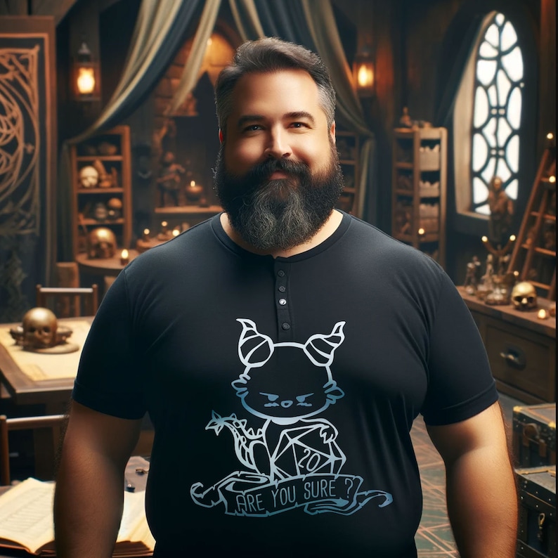 May include: A man wearing a black t-shirt with a white graphic of a cartoon dragon holding a twenty-sided die. The graphic says "Are you sure?"