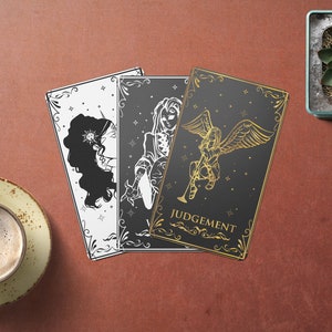 May include: Three tarot cards with black and white illustrations on a red background. The card on the right is black with gold lettering and the text "JUDGEMENT".
