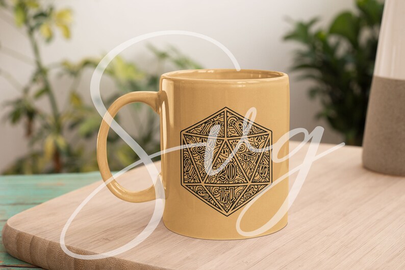 Puede incluir: Una taza de cer&aacute;mica amarilla con un gr&aacute;fico en blanco y negro de un dado de 20 caras. El dado est&aacute; dise&ntilde;ado de forma intrincada con un patr&oacute;n de l&iacute;neas y remolinos.