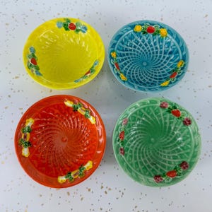 Puede incluir: Cuatro cuencos de cerámica coloridos. Cada cuenco es de un color diferente: amarillo, azul, rojo y verde. Los cuencos tienen un diseño en espiral y están decorados con un patrón floral alrededor del borde. Estos cuencos decorativos son perfectos.