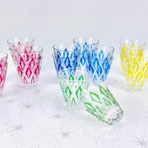 Puede incluir: Conjunto de 10 vasos de beber vintage con un patrón geométrico en azul, verde, amarillo y rosa. Los vasos son transparentes y tienen un diseño único.