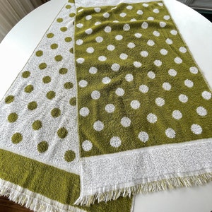 May include: Two green and white kitchen towels with a polka dot pattern. The towels have a fringe border.