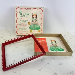 May include: A vintage red metal weaving loom, with a box displaying a girl in a green dress. The box is labelled "Melly Bee Metal Weaving Loom", with instructions and an image of the finished product.