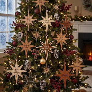 May include: A collection of wooden star-shaped Christmas ornaments hanging on a green tree. Each star features engraved religious titles such as King of Kings, Son of God, Alpha and Omega, Immanuel, Redeemer, Saviour, Lamb of God, and Son of Man.