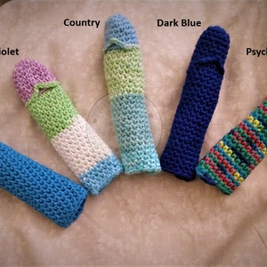 May include: A collection of five handmade, knitted cozies in various colors. The cozies are labeled "Dazzle Blue", "Violet", "Country", "Dark Blue", and "Psychedelic". Each cozy has a unique color scheme, with some featuring multiple colors.