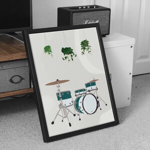 May include: A framed print of a green and white drum set with hanging plants in the background. The drum set is a three-piece set with a bass drum, a snare drum, and a floor tom.