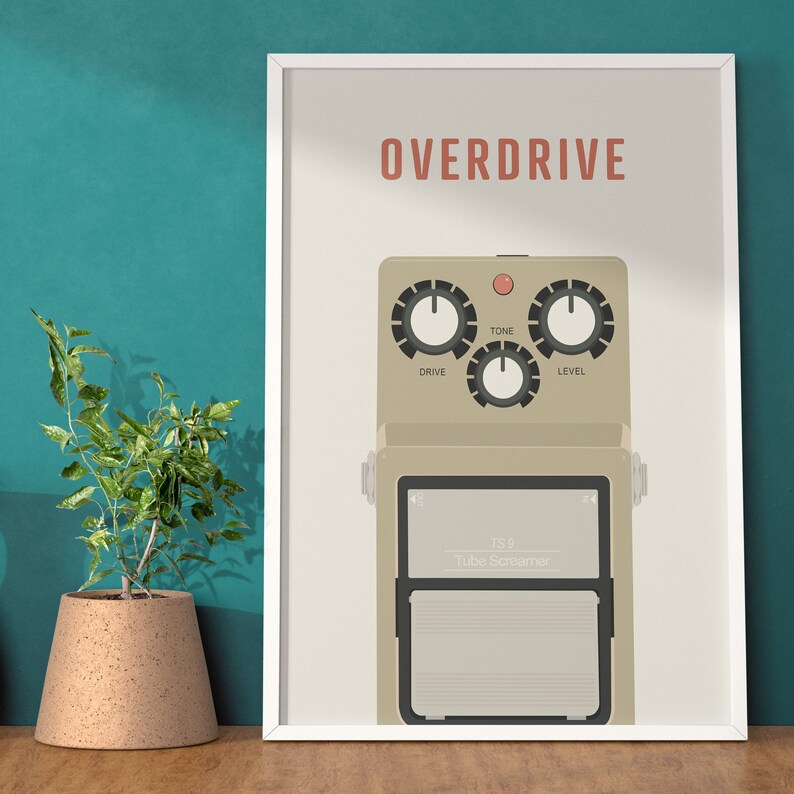 Pu&ograve; includere: Un poster incorniciato bianco con la parola "OVERDRIVE" in rosso. Il poster presenta un'illustrazione beige di un pedale per chitarra con tre manopole etichettate "DRIVE", "TONE" e "LEVEL". Il pedale ha un rettangolo nero con il testo "TS9 Tube Screamer".