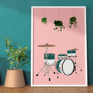 May include: A pink framed print with a white background featuring a drum set with green and white drums and cymbals. Three hanging plants with green leaves are in the background.