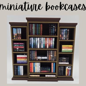 May include: Miniature bookcases with a dark brown finish and gold trim, filled with tiny books of various colors. The text "miniature bookcases" is at the top. The bookcases are arranged in a three-section design, perfect for dollhouses or decorative displays.