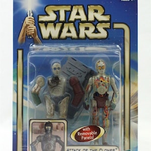 Könnte beinhalten: Eine Star Wars Actionfigur von C-3PO aus dem Film Angriff der Klonkrieger. Die Figur hat abnehmbare Teile und ist in einer blauen und silbernen Schachtel mit dem Star Wars Logo verpackt.