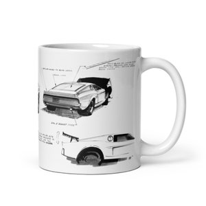 May include: A white ceramic mug with a black and white illustration of a car design. The illustration includes notes and details about the car's design.