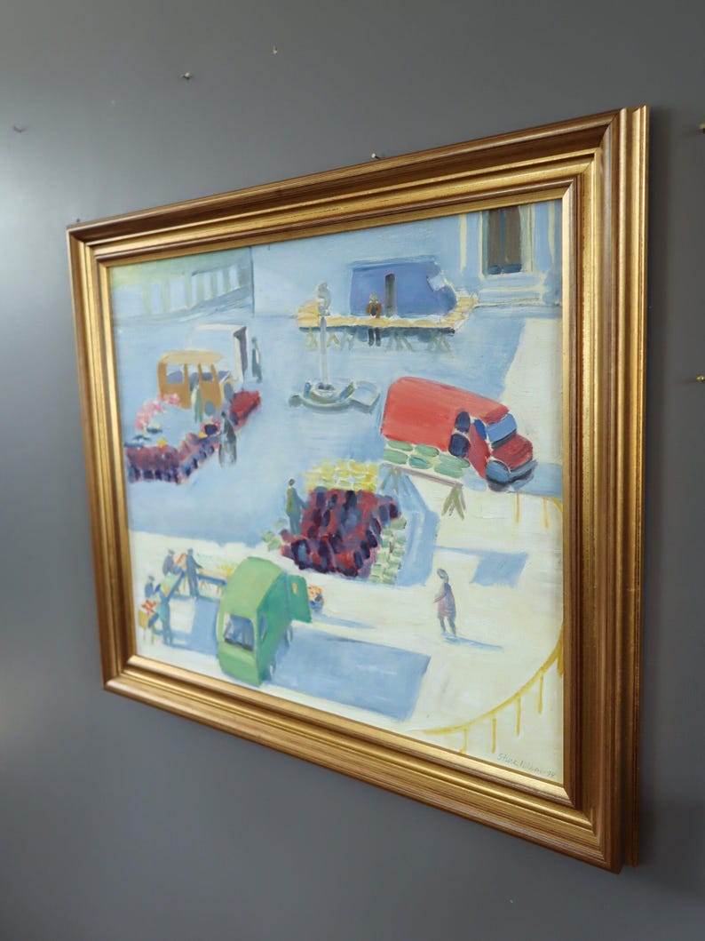 Pode incluir: Pintura a &oacute;leo numa moldura dourada que retrata uma cena de rua com figuras, ve&iacute;culos e bancas de mercado. A obra utiliza azuis, vermelhos, verdes e amarelos, criando uma composi&ccedil;&atilde;o din&acirc;mica. A pintura est&aacute; assinada no canto inferior direito.