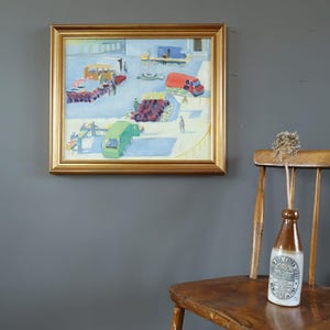 Pode incluir: Uma pintura a &oacute;leo emoldurada mostra uma cena de mercado com ve&iacute;culos coloridos. Uma garrafa vintage castanha e branca com texto est&aacute; numa cadeira de madeira. O fundo &eacute; uma parede cinzenta escura.