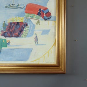 Pode incluir: Uma pintura a &oacute;leo emoldurada que retrata uma cena de mercado com um caminh&atilde;o vermelho, figuras e produtos. A obra de arte usa azuis, vermelhos, verdes e amarelos, criando uma atmosfera vibrante. A pintura &eacute; assinada no canto inferior direito. A moldura &eacute; dourada.