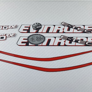 May include: A set of white and black Evinrude E-TEC decals with red accents. The decals include the Evinrude logo, the E-TEC logo, and the text "Evinrude 40". There is also a silver decal with the text "Evinrude 2006 Emissions Standards".