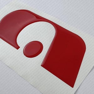Reprodução de adesivo 3D com letra em relevo e cúpula do logotipo Adria 1 x 18,7 cm