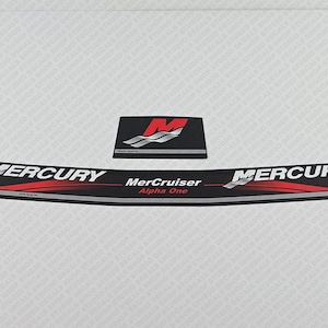 Może przedstawiać: Czarno-biała naklejka z czerwonym napisem na łódź. Naklejka zawiera napis "Mercury" i "MerCruiser Alpha One".