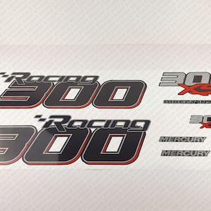Könnte beinhalten: Ein Satz schwarzer und silberner Aufkleber mit roten Akzenten. Die Aufkleber zeigen den Text "Racing 300" und "300 XS Direct Injection". Die Aufkleber enthalten auch das Mercury-Logo.