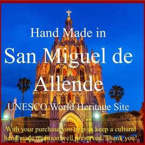 K&ouml;nnte beinhalten: Handgefertigt in San Miguel de Allende, einem UNESCO-Weltkulturerbe. Das Bild zeigt eine hell beleuchtete Kirche bei Nacht mit blauem Himmel und Palmen im Vordergrund. Der Text "Hand Made in San Miguel de Allende UNESCO World Heritage Site" ist auf dem Bild zu sehen.