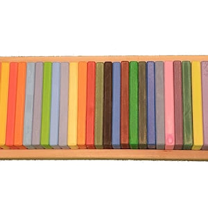 May include: A wooden box filled with colorful wooden blocks. The blocks are arranged in a rainbow pattern.