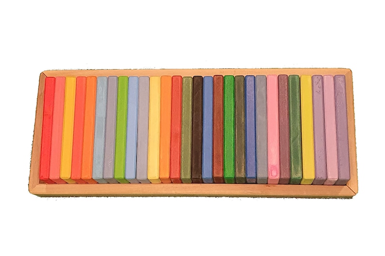 May include: A wooden box filled with colorful wooden blocks. The blocks are arranged in a rainbow pattern.