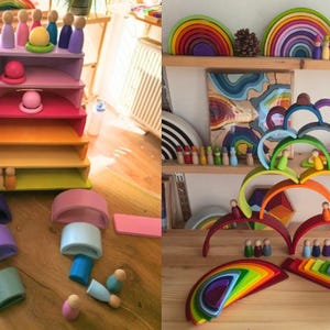 May include: A collection of wooden rainbow stacking arches and small peg dolls in various colors. The set includes semi-circular pieces, rectangular platforms, and arched segments arranged in tiered structures and scattered on a wooden surface.