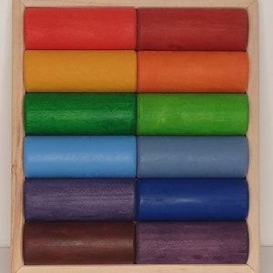 May include: A wooden rainbow stacking toy with 12 colorful cylinders in a wooden frame. The cylinders are arranged in a rainbow pattern, starting with red and ending with purple.