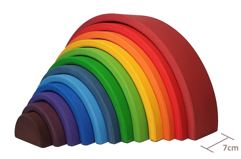 May include: A rainbow-colored wooden arch toy with 12 pieces. The pieces are arranged in a semi-circle, with the largest piece at the top and the smallest piece at the bottom. The toy is 7 inches wide.