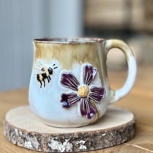 Peut inclure: Ensemble de trois tasses en céramique avec une finition mate et mouchetée. Les tasses sont dans des tons crème, gris clair et gris foncé. Chaque tasse a un design simple et minimaliste, parfait pour le café ou le thé.