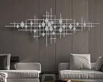 May include: A modern living room with a gray sectional sofa, a gray armchair, and a coffee table with two tiers. The wall behind the sofa features a large metal wall sculpture with a geometric design.