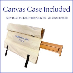May include: A wooden easel with a canvas case. The canvas case is beige with black straps and the text "Morningside Mahogany" in blue. The text "Canvas Case Included" is at the top.