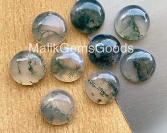 May include: A collection of eight round, polished moss agate cabochons. The translucent stones display green, white, and brown inclusions, resembling miniature landscapes. The text "Malik Gems Goods" is visible in the image.