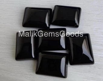 May include: Six black square-shaped gemstones, each with a smooth, polished surface. The gemstones are arranged in a staggered pattern on a white surface. The text "MalikGemsGoods" is visible in the center of the image.