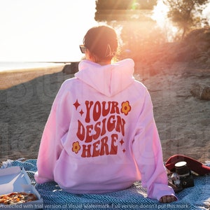 Puede incluir: Una sudadera con capucha rosa con el texto "YOUR DESIGN HERE" en rojo y amarillo en la espalda. La sudadera tiene un dise&ntilde;o de flor y estrella.