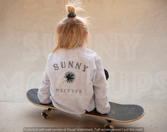 Może przedstawiać: Szara bluza z napisem "SUNNY" i grafiką palmy na plecach. Bluzę nosi osoba siedząca na deskorolce.
