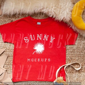 Könnte beinhalten: Rotes T-Shirt mit weißem Text "SUNNY MOCKUPS" und einer weißen Palmengrafik.