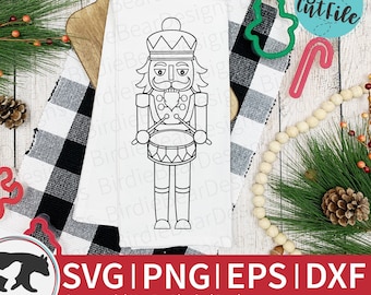 May include: A black and white line art illustration of a nutcracker holding drumsticks and a drum. The nutcracker is wearing a hat with a plume and has a mustache and beard. The image is on a white background.