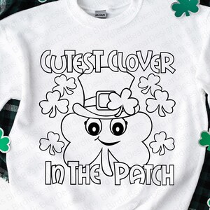 Pu&ograve; includere: Felpa bianca con grafica in bianco e nero di un trifoglio con cappello, circondato da trifogli. Il testo recita "Cutest Clover In The Patch". Adatta per la festa di San Patrizio.