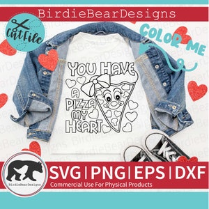 May include: A white t-shirt with a black and white design of a pizza slice with a face and the text "You Have A Pizza My Heart". The design is surrounded by hearts. The t-shirt is laying on a blue denim jacket and a white surface.