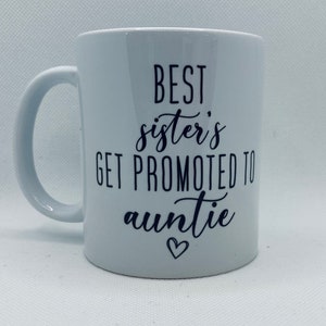 May include: White ceramic mug with black text that reads "Best sister's get promoted to auntie" with a small heart symbol.