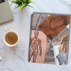 May include: A spiral bound notebook with a collage of vintage anatomical illustrations. The cover features a human body with internal organs, a heart, a hand, and a skull.
